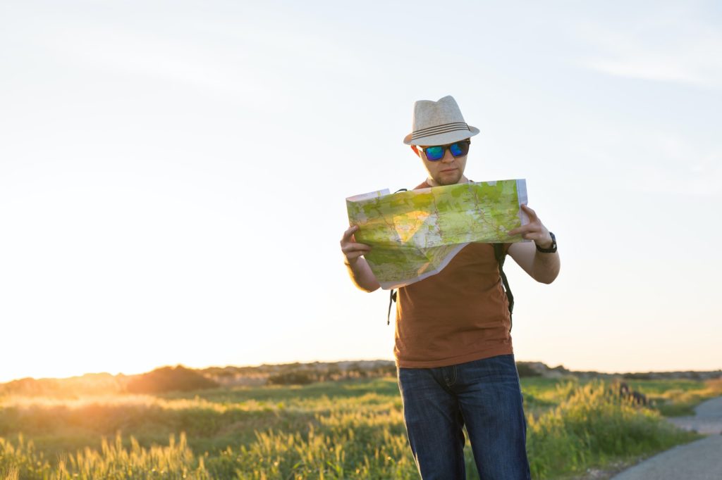 Young man traveling and looking at the travel map